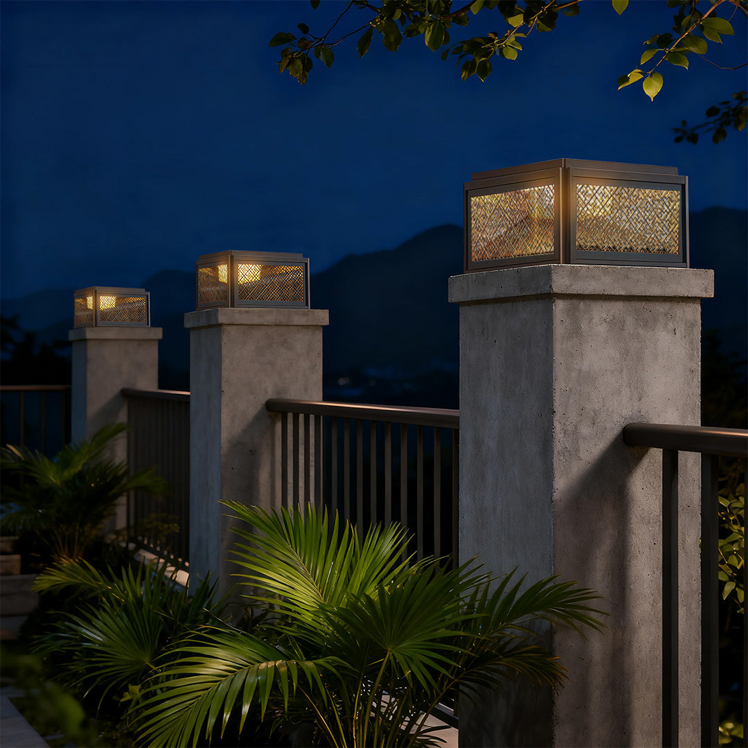 Decorative pillar light in a garden with plants, adding a sophisticated touch to the outdoor space.
