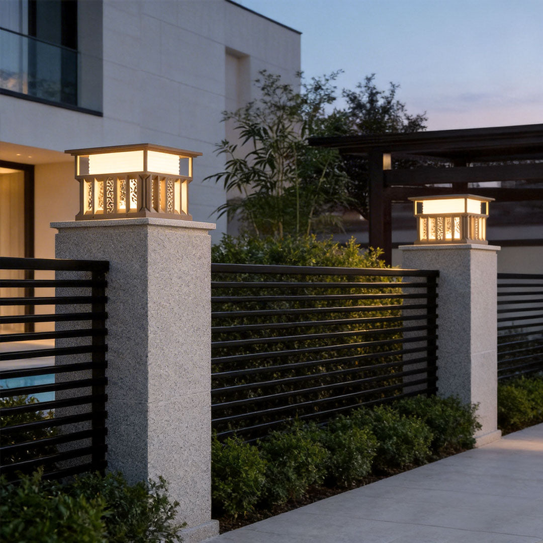 Decorative pillar lights for house with intricate patterns, installed along a modern fence.
