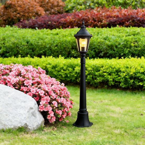 Decorative post light illuminating a lush garden pathway with warm vintage glow.