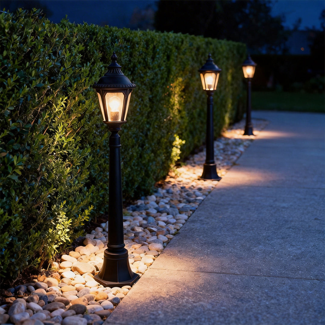 Decorative post light providing soft illumination along a stylish driveway.