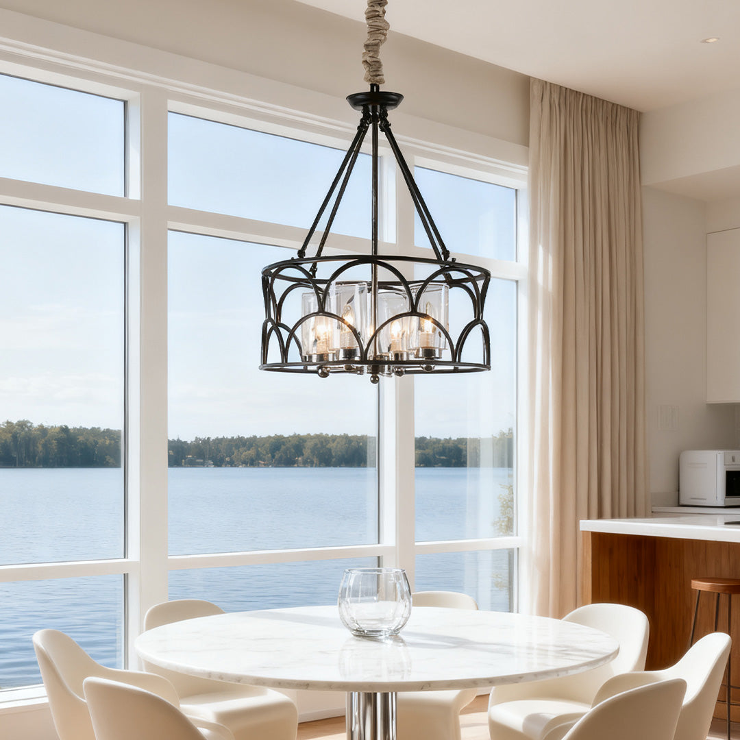 Large decorative chandelier with black circular frame, suspended in a bright dining area with floor-to-ceiling windows and a breathtaking lake view.