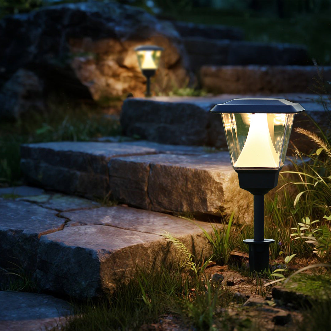 Decorative solar pathway lights creating ambient lighting along stone garden walkway with plants