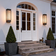 Decorative square wall sconce light on a stone facade, creating a welcoming ambiance for outdoor spaces.