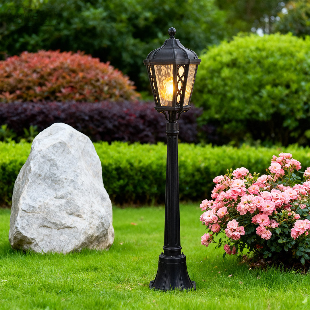 Bollard light beside a decorative stone, stylish and warm outdoor lighting solution