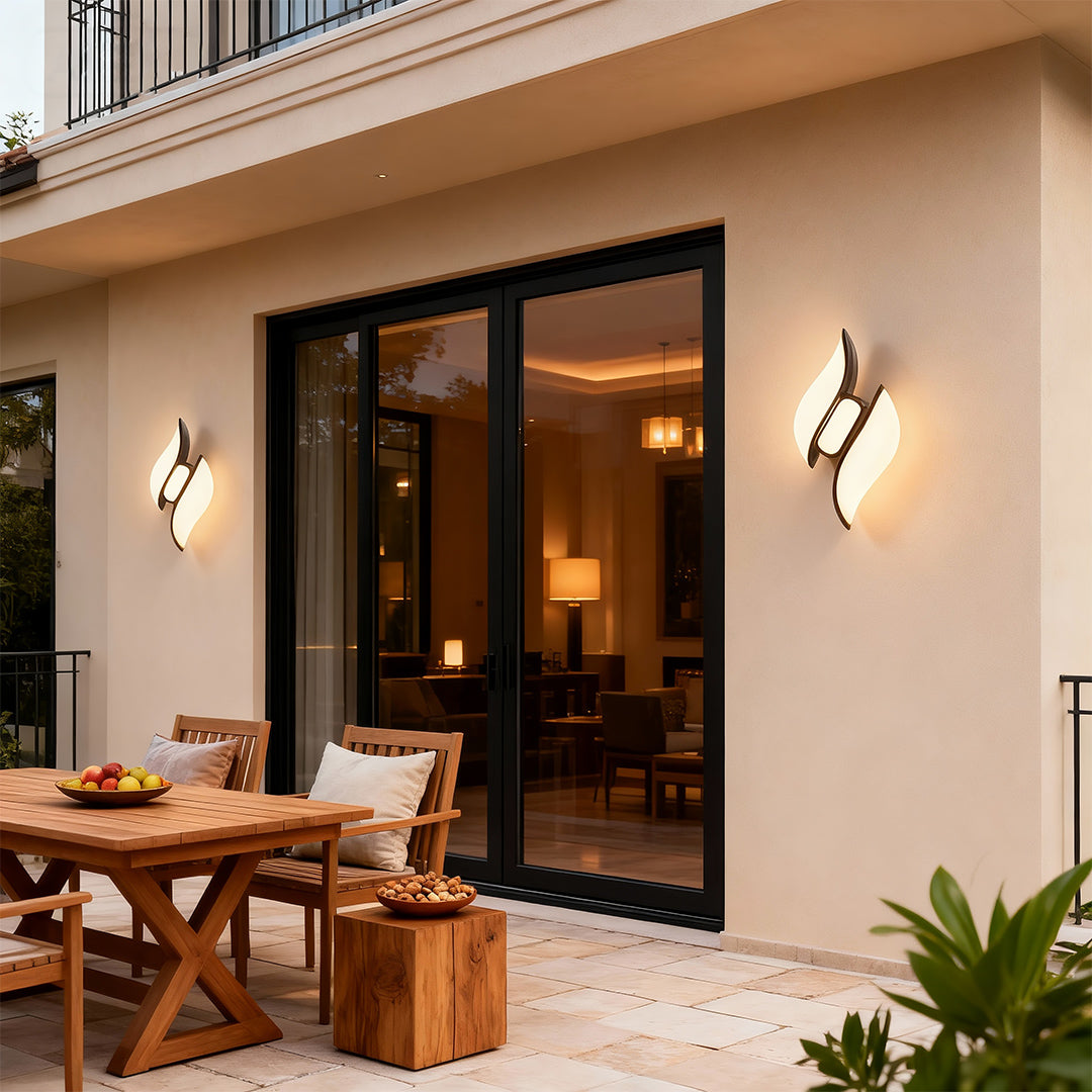 Designer black outdoor wall sconces with glass shade chandelier aesthetic providing architectural accent lighting on contemporary patio.