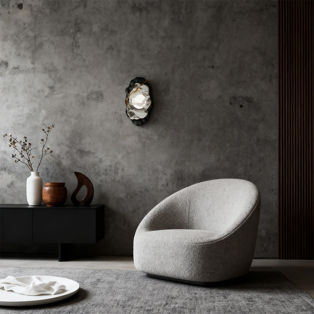 Designer black wall light illuminating concrete wall above curved white seating in modern space