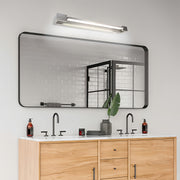 Designer chrome bathroom vanity light installed in modern bathroom above wooden vanity cabinet