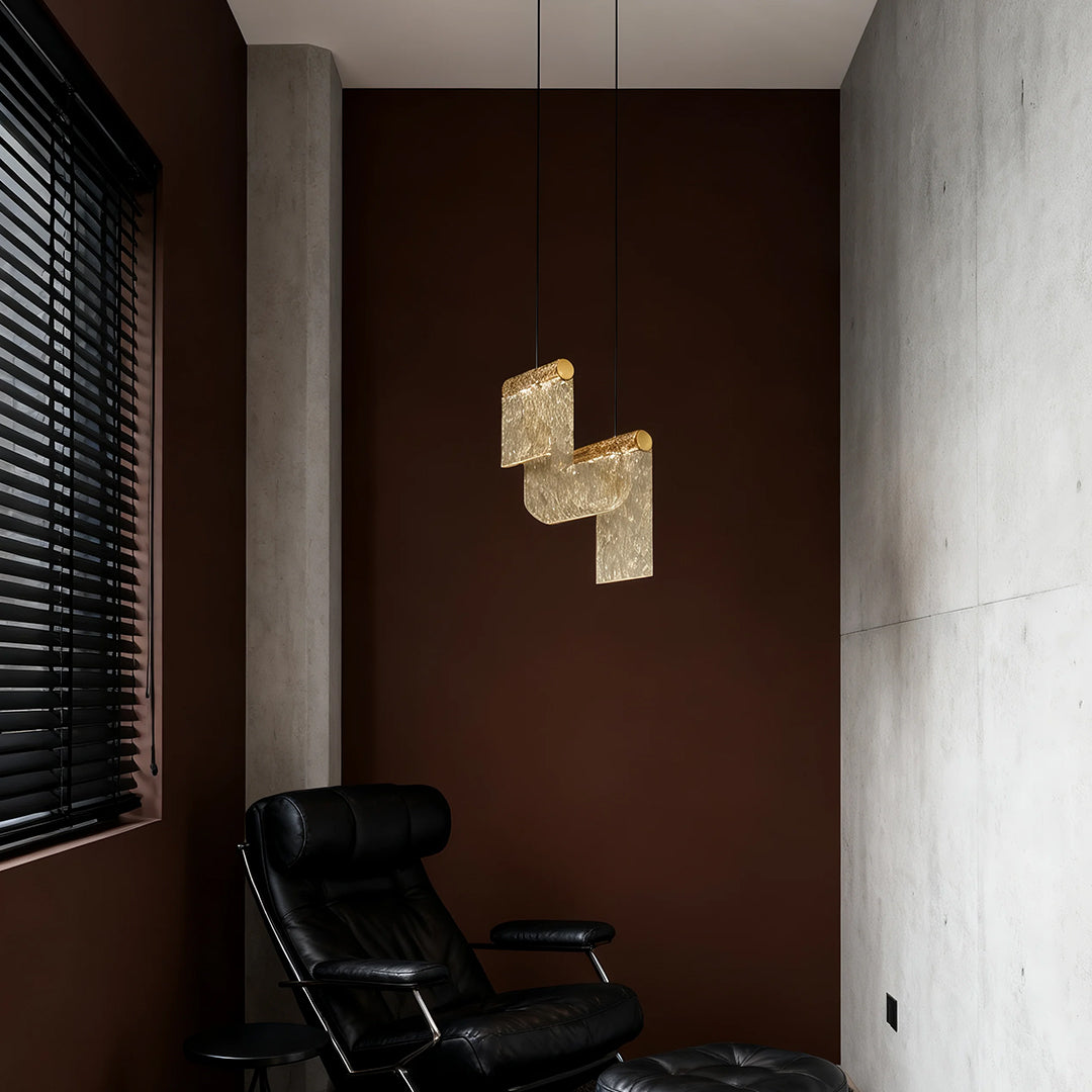 Designer gold pendant island light accenting minimalist hallway with brown wood paneling and white walls