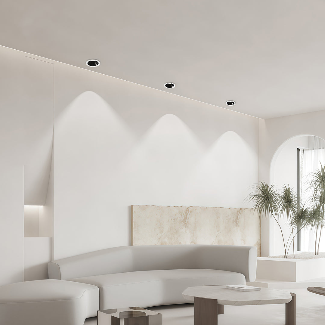 Designer interior spotlights with glass shade chandelier influence highlighting elegant beige living room with warm glow.