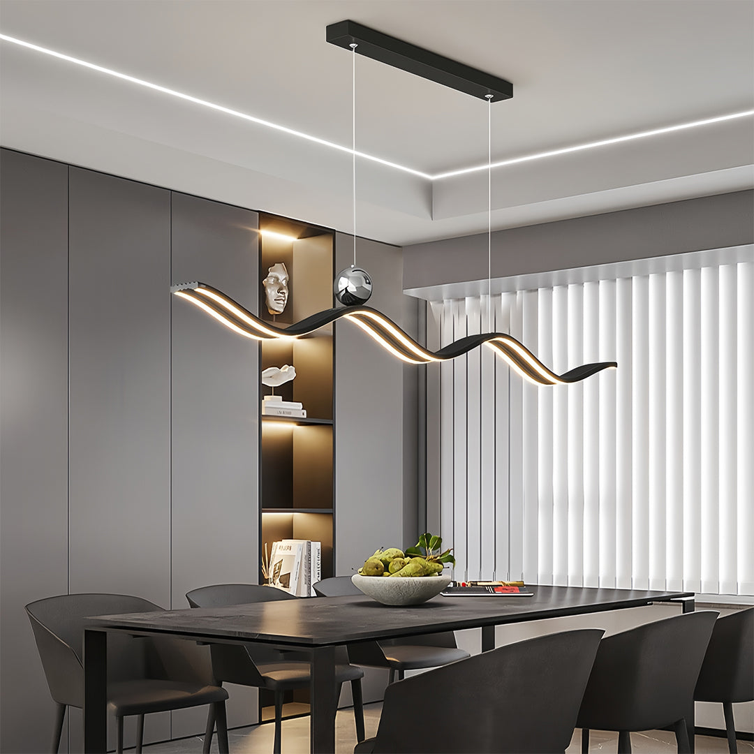 Designer linear led pendant light illuminating a long, dark dining table, enhancing the vertical space in a minimalist setting.