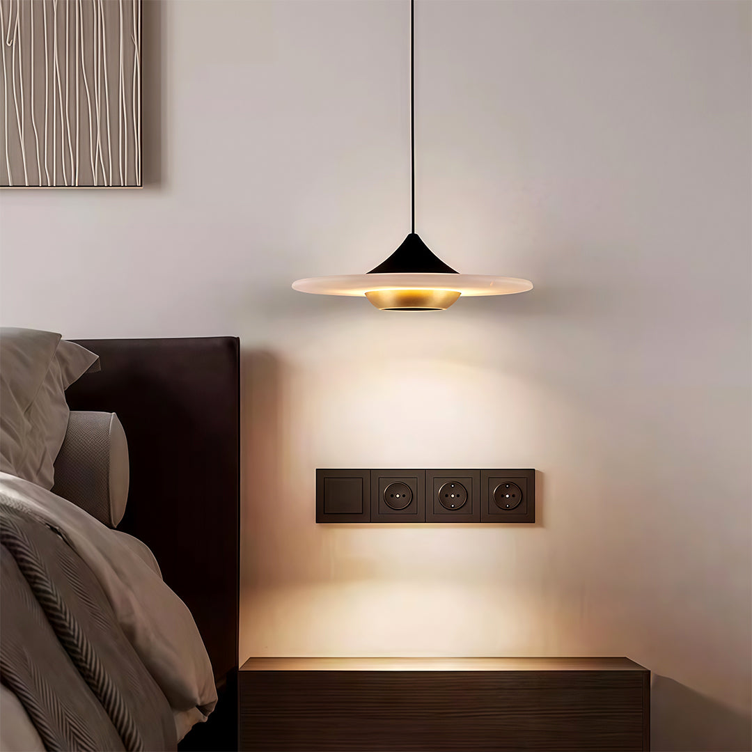 Designer modern LED pendant lights with glass shade chandelier influence creating warm accent glow in contemporary bedroom setting.