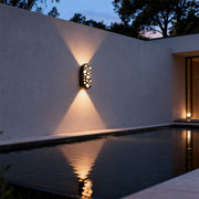 Designer outdoor up down wall lights with glass shade chandelier aesthetic creating beautiful ambient glow beside modern pool at twilight.