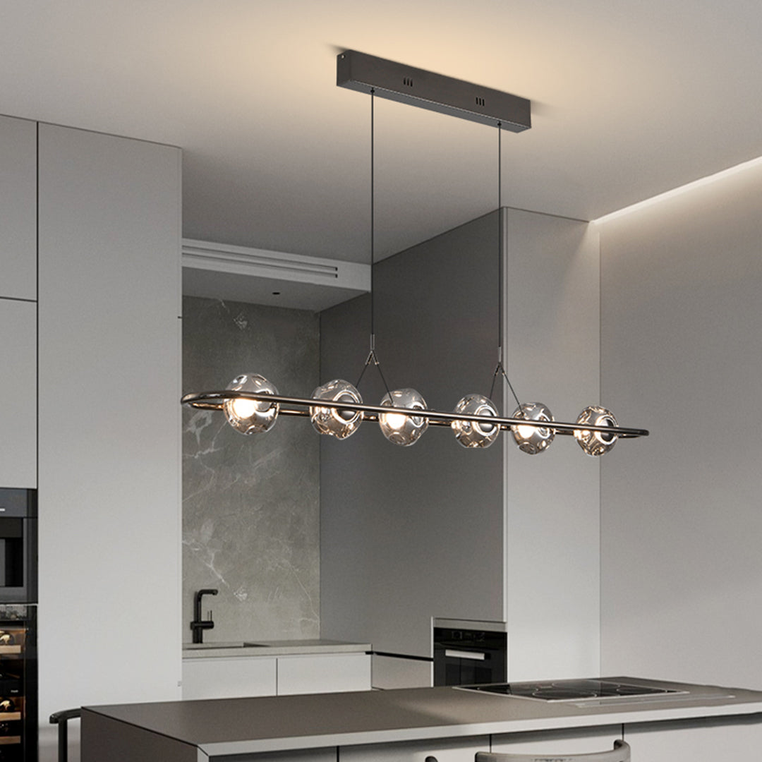 Designer rise and fall pendant light installation over modern kitchen island with chrome spheres