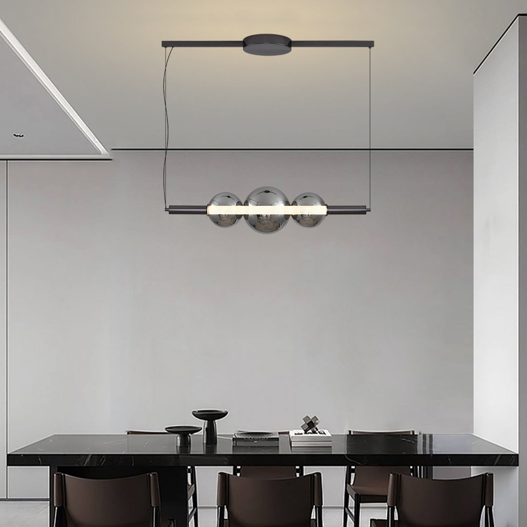 Designer silver pendant light for kitchen island installation in modern dining area with sleek black cabinetry