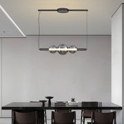 Designer silver pendant light for kitchen island installation in modern dining area with sleek black cabinetry