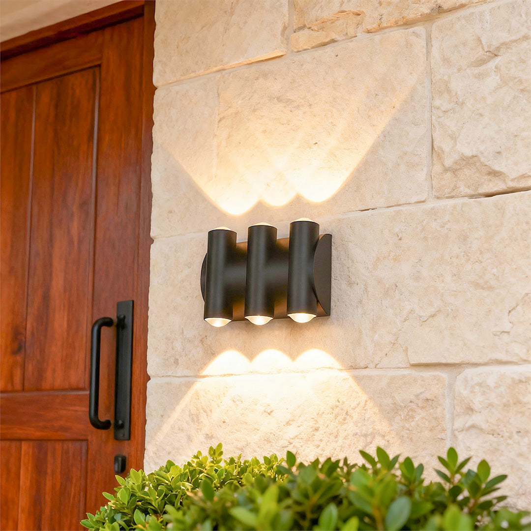 Designer up down lighting wall lights with glass shade chandelier aesthetic creating beautiful illumination on rustic stone exterior.