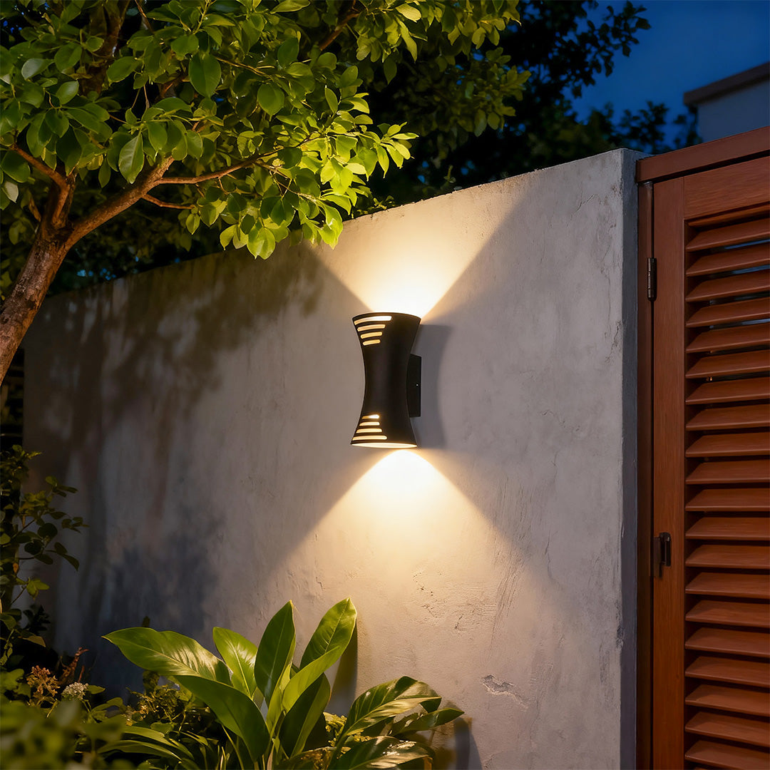 Designer up down lighting wall sconce with glass shade chandelier aesthetic creating beautiful ambient glow at twilight entrance.