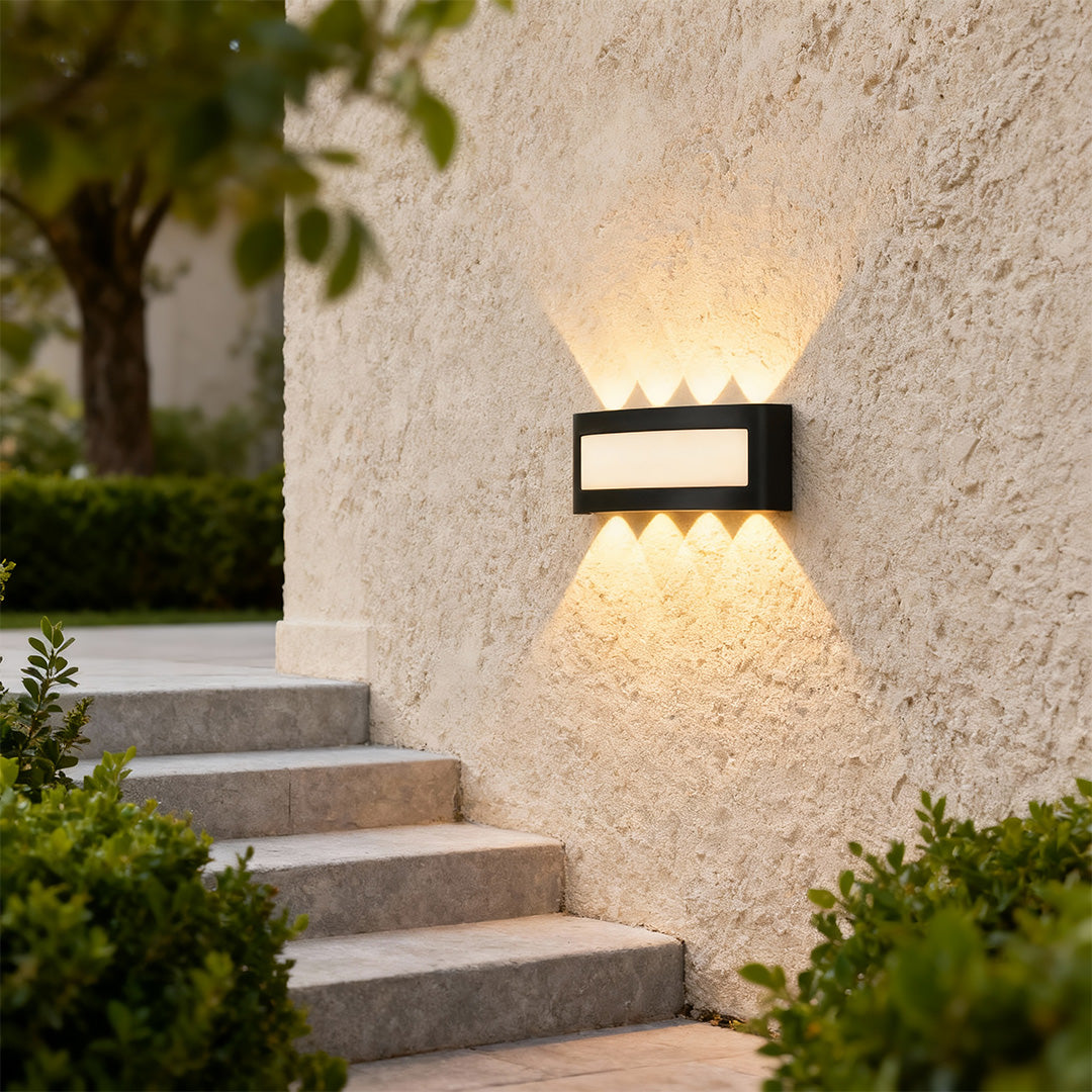 Designer up down wall lights with glass shade chandelier aesthetic creating beautiful upward and downward illumination on stone wall.