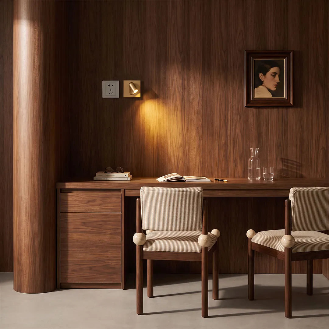Wall mounted LED reading light illuminating a wood-paneled desk and compact study area.