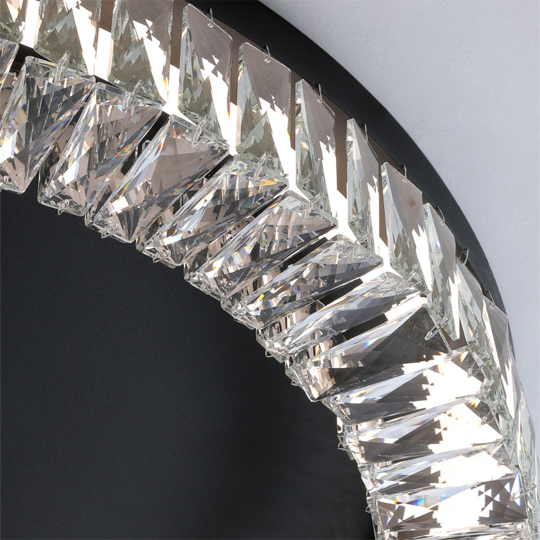 Detail shot of black ceiling flush mount light revealing faceted crystal elements against dark background.