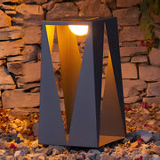 Close-up detail of landscape lighting flood lights showing premium construction and warm LED technology against textured stone surface