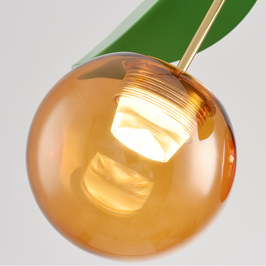 Detailed view of glass globe pendant light fixture showing amber orb with warm illumination