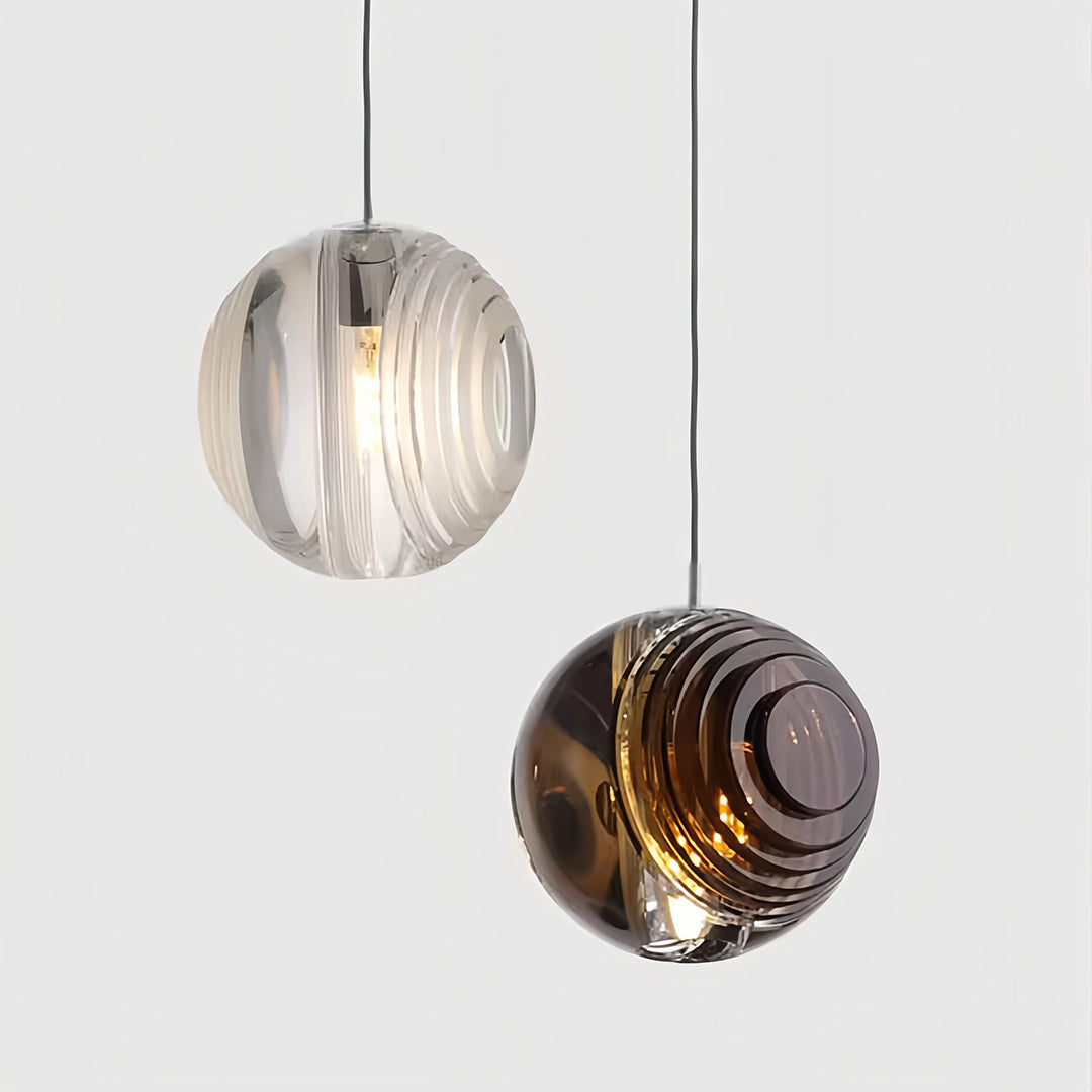 Detailed view of metal pendant lights with smoked glass spheres, highlighting their intricate design and texture.