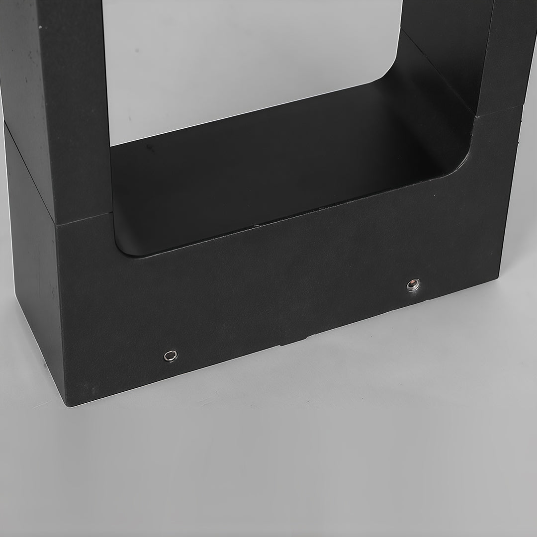 Detailed view of the base of a pathway bollard light, emphasizing the sturdy black structure.