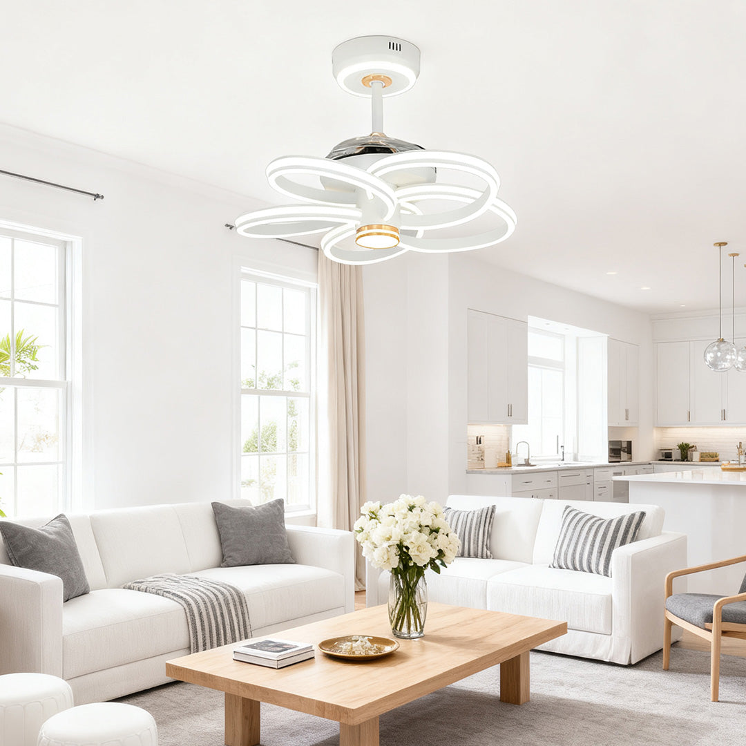 Detailed view of the transparent blades and pink/rainbow base of the ceiling fans white with light fixture. 