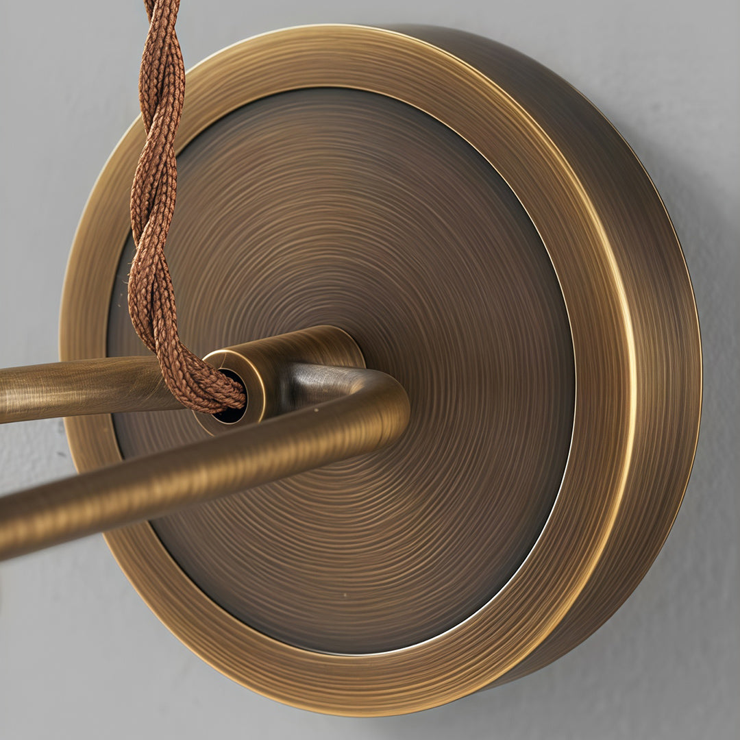 Detailed view of indoor wall mount lights with glass shade chandelier design highlighting antique brass backplate and mounting detail.