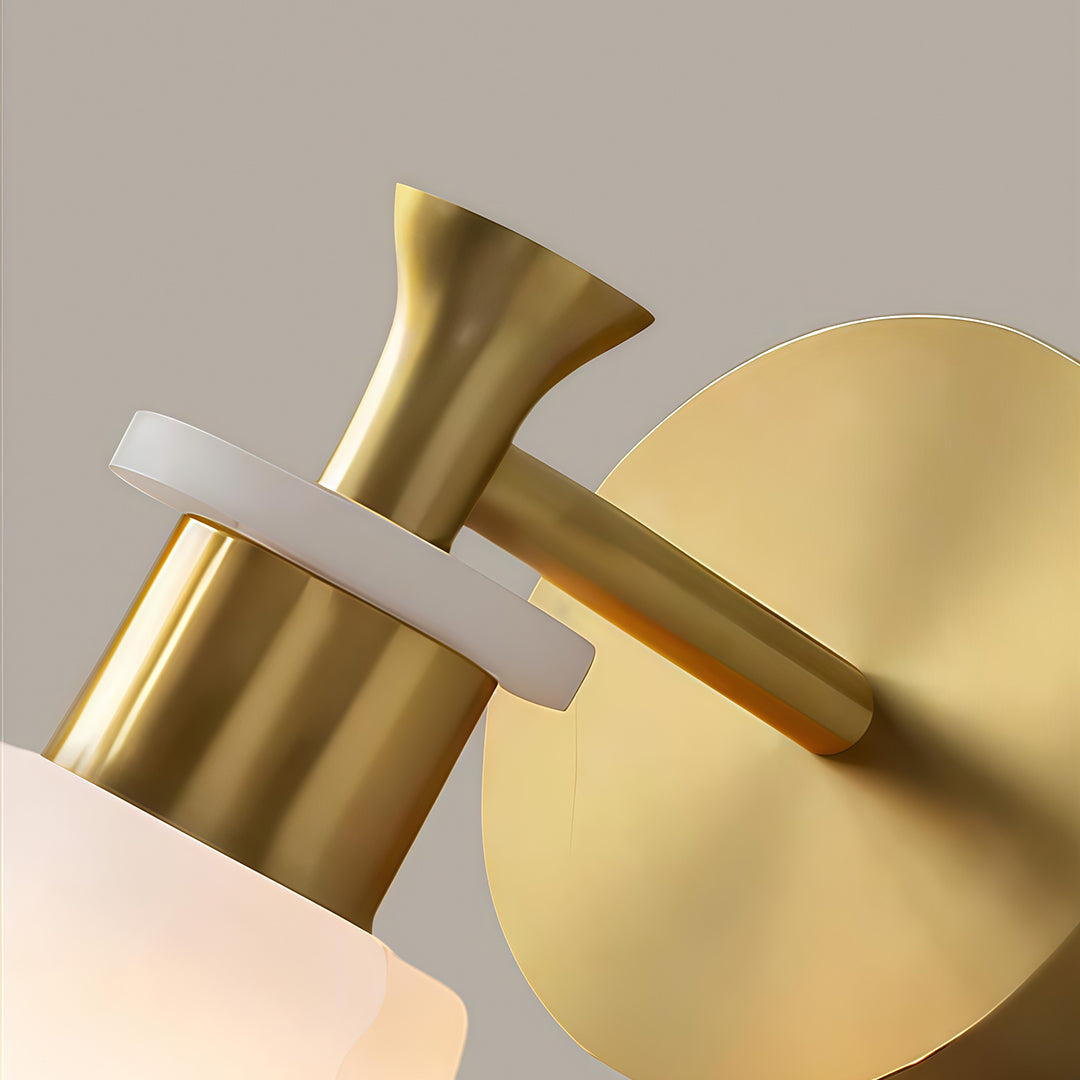 Detailed view of wall sconce LED light featuring glass shade chandelier design showing brushed brass construction detail.