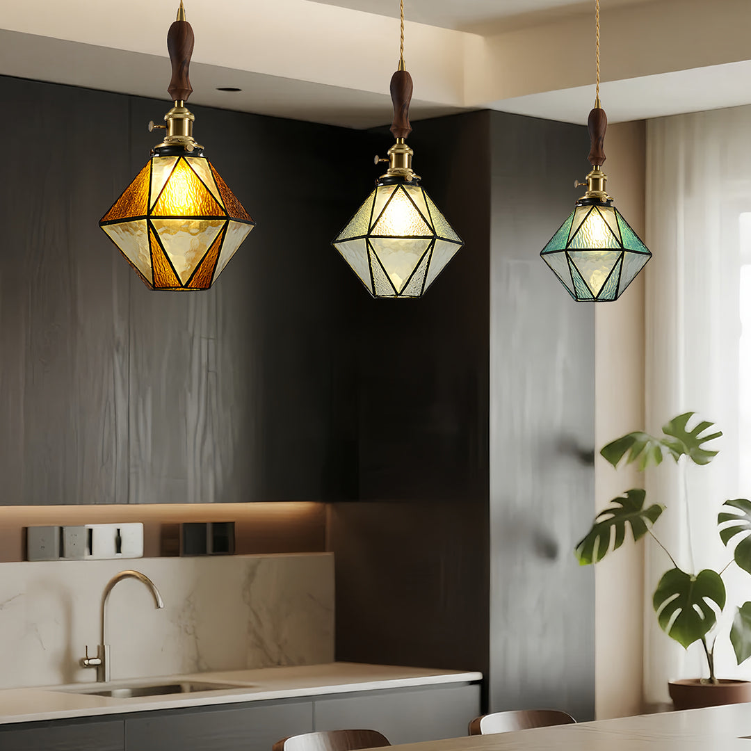 Diamond-shaped pendant lights illuminating modern kitchen island with white counters and clean minimalist design