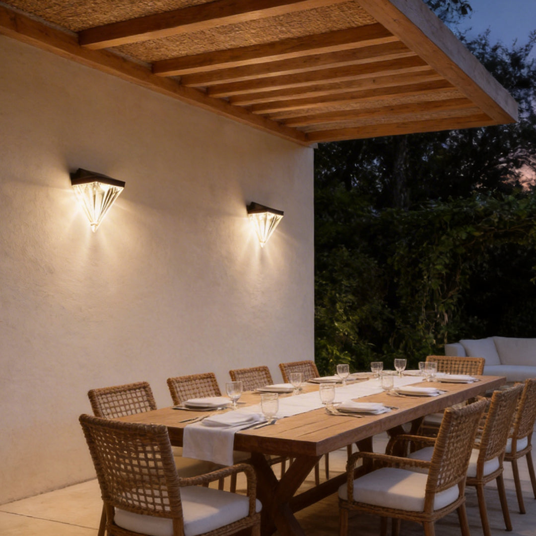 Diamond wall lights illuminating a minimalist outdoor dining area with focused glow.