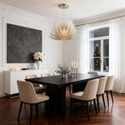 Deco chandelier lighting fixture installed above dining table.