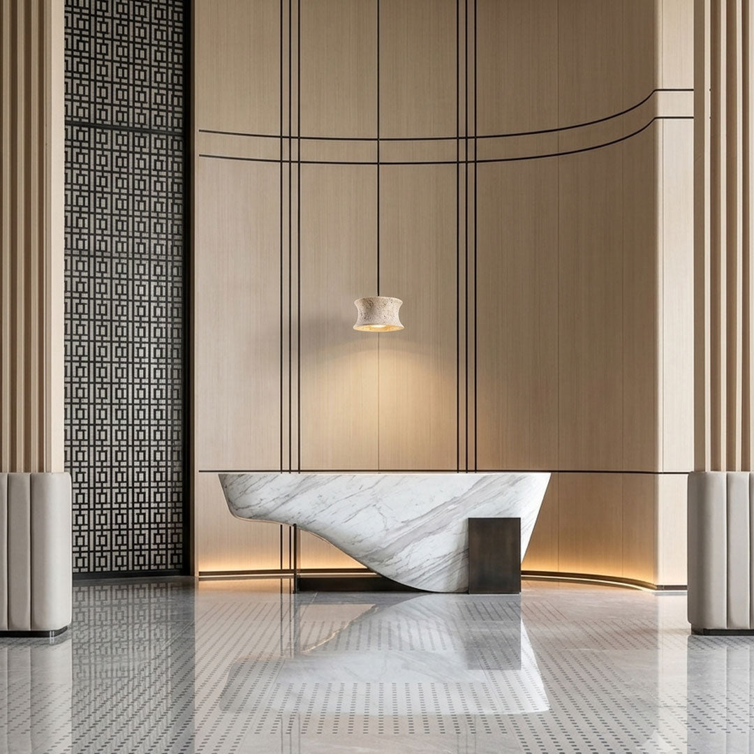 Drum pendant light fixture suspended above a minimalist dining table in a contemporary room.