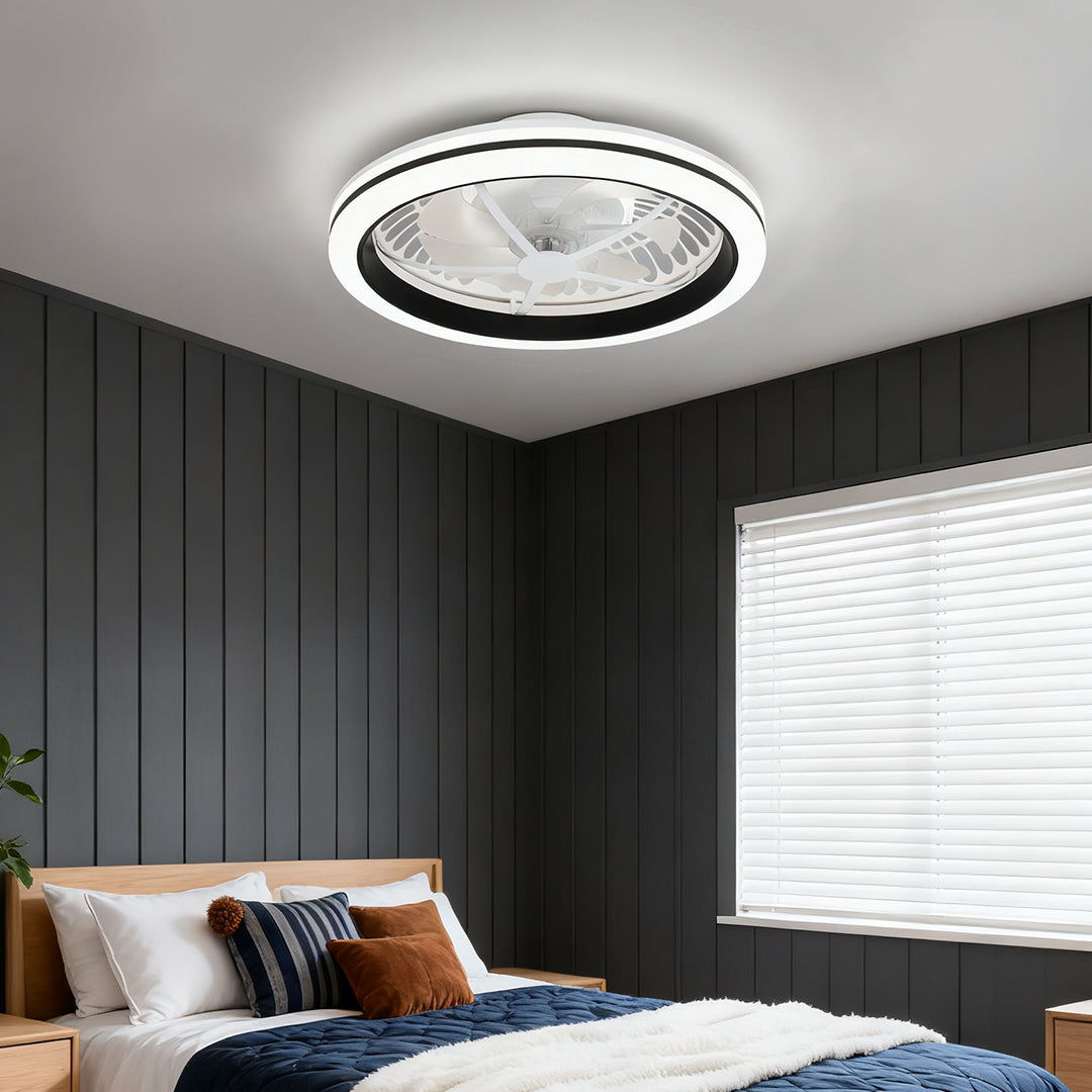 Discreet white flush mount ceiling fan with light installed against a dark shiplap wall in a stylish, masculine bedroom. 