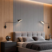 Double arm wall sconce installed above a modern bed, providing adjustable bedside reading light in a warm bedroom.