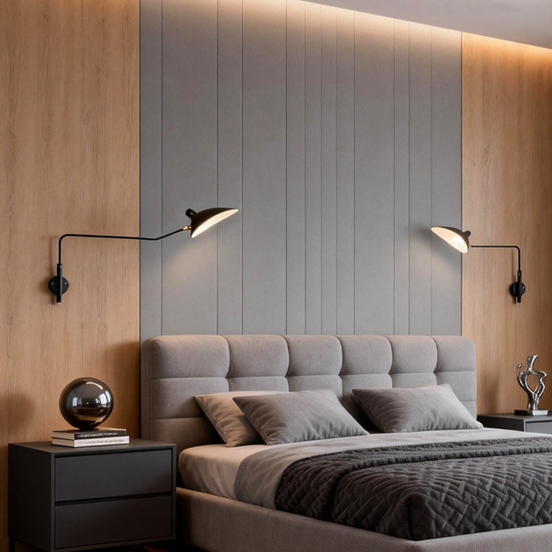 Double arm wall sconce installed above a modern bed, providing adjustable bedside reading light in a warm bedroom.