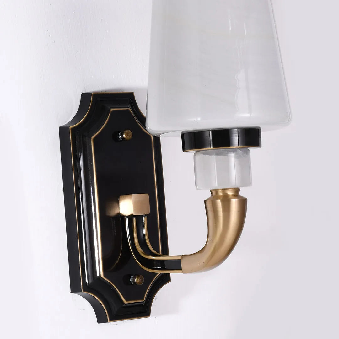Brass candle sconces wall close-up featuring double arms, black base, and white lampshades.