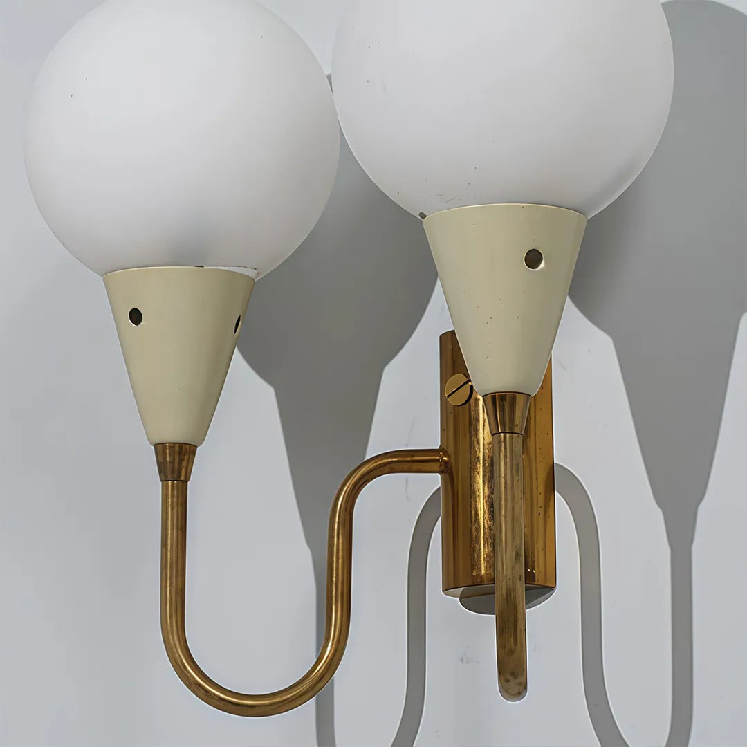 Double globe wall sconce detail view showing the frosted glass globes and curved arms.