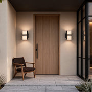 Modern double head wall light mounted beside a front door, creating warm and balanced outdoor illumination for a contemporary entrance.