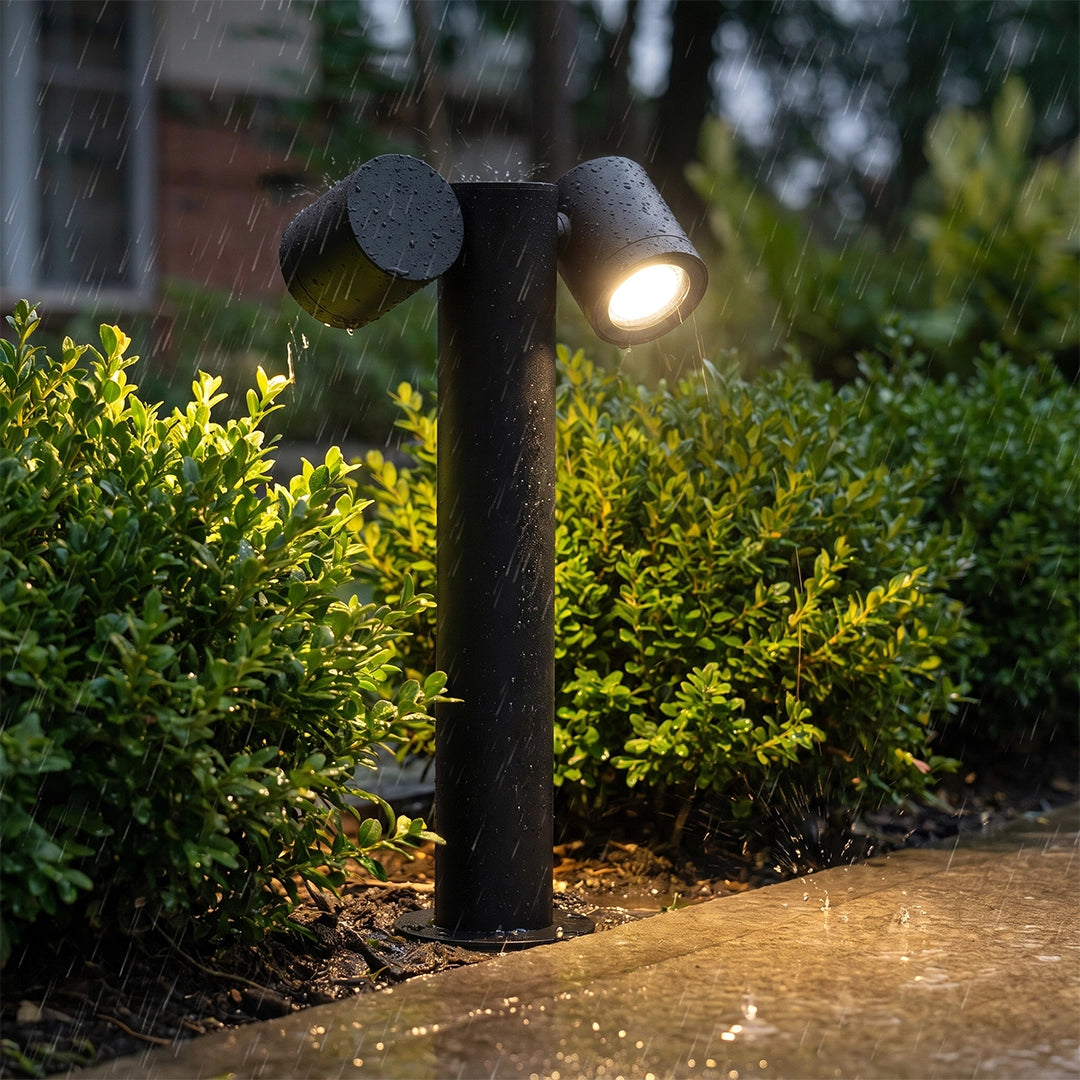 Close-up of a double light bollard light with two angled heads and a black cylindrical post.