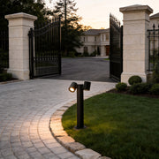 Double light bollard light illuminating a garden entrance pathway with warm glow.