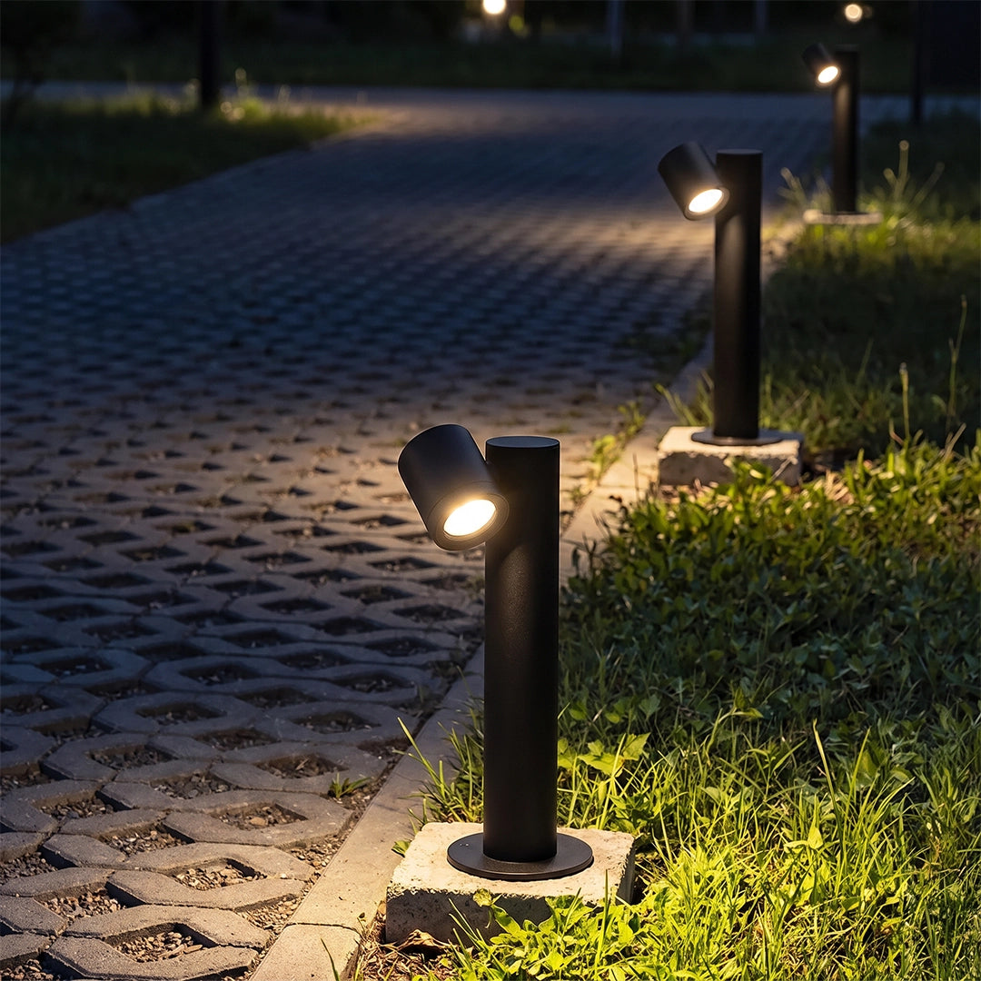 Double light bollard lights placed along a paved walkway, providing warm pathway lighting at night.