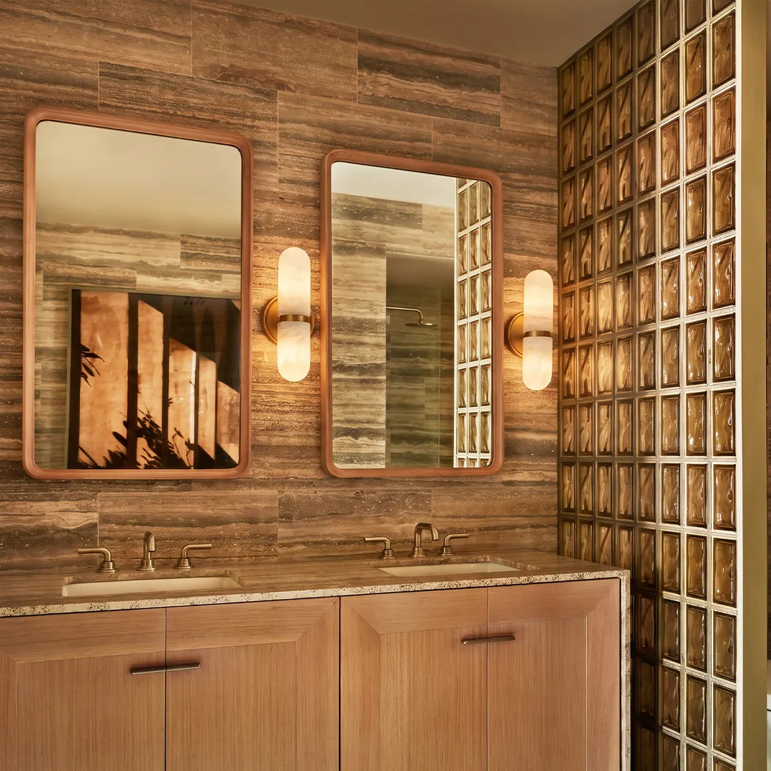 Double light wall sconce placed above a bathroom vanity with natural wood finishes.