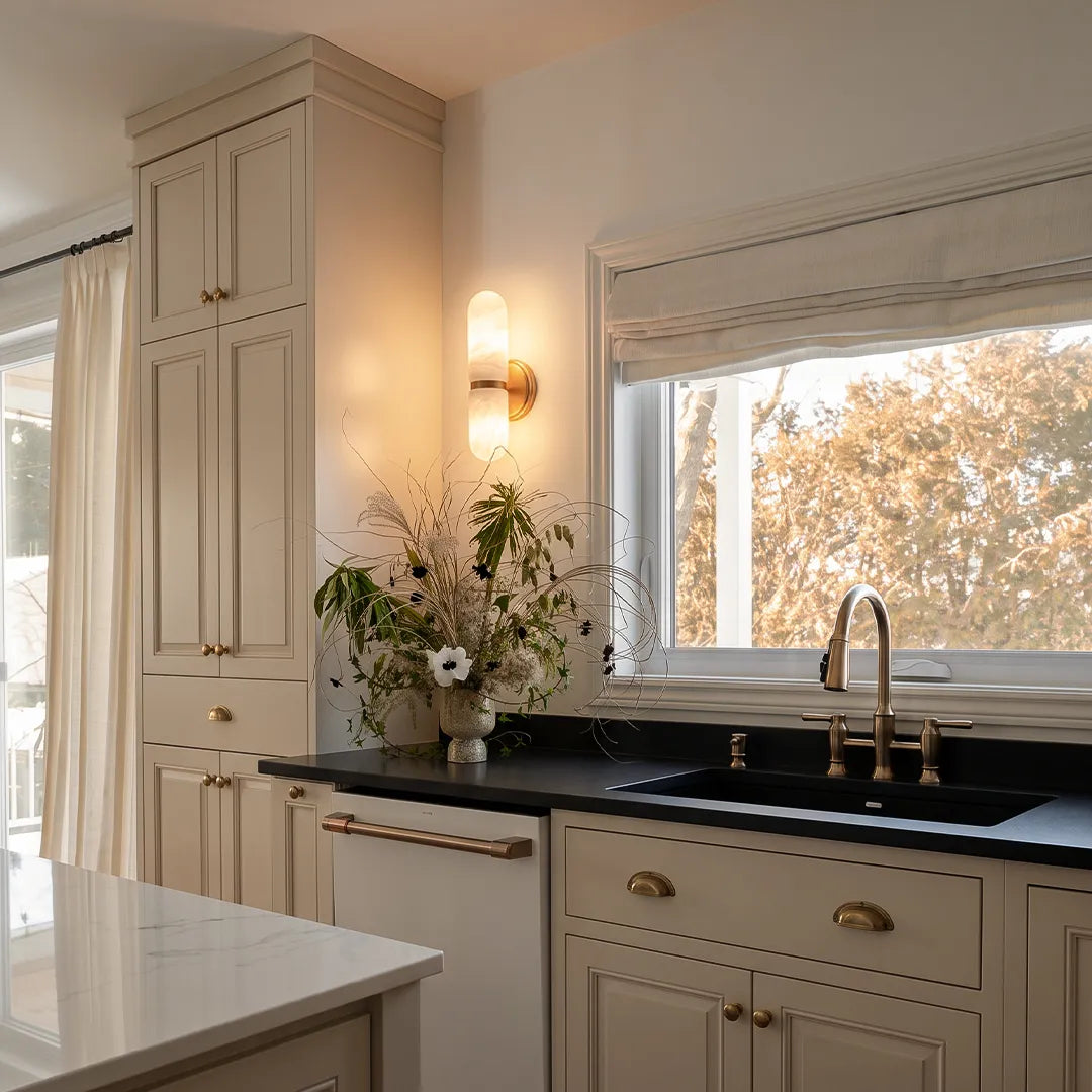 Double light wall sconce installed in a kitchen area with warm decorative illumination.