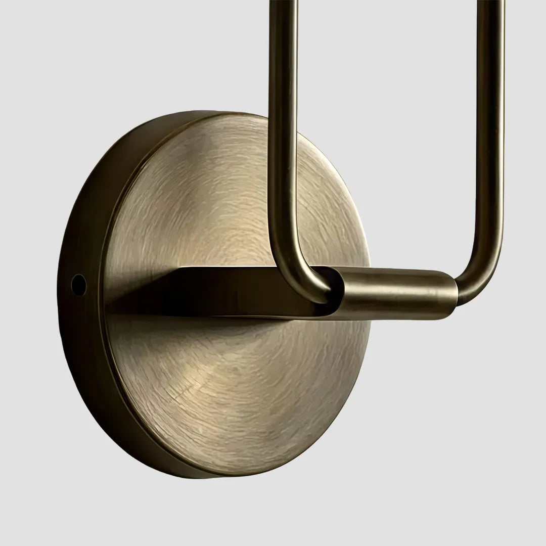 Double sconce wall light detail showing the round backplate and curved metal arm design.