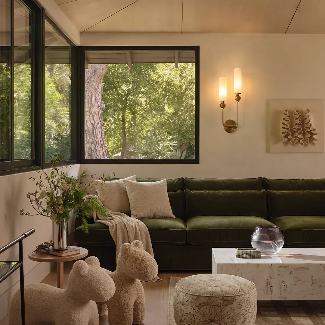 Double sconce wall light illuminating a modern living room wall with warm accent lighting.