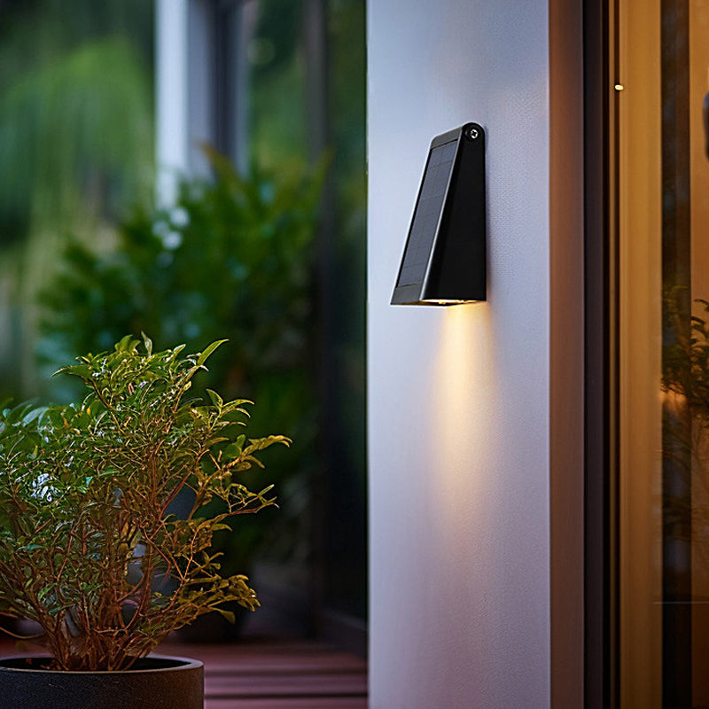 Down light wall sconce installed on a patio wall near plants