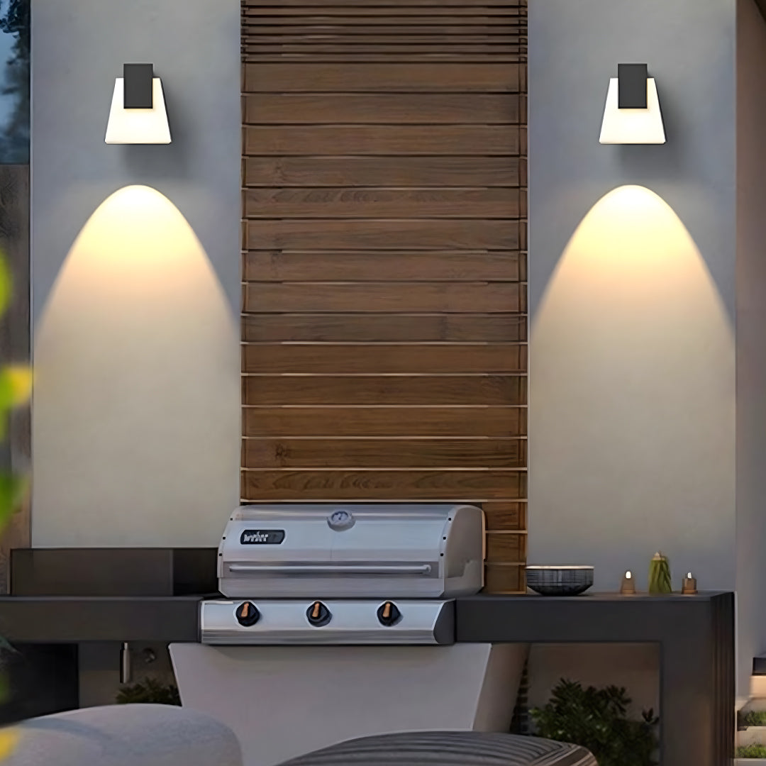 Wall mounted outdoor lights casting elegant downward lighting on a textured exterior wall.